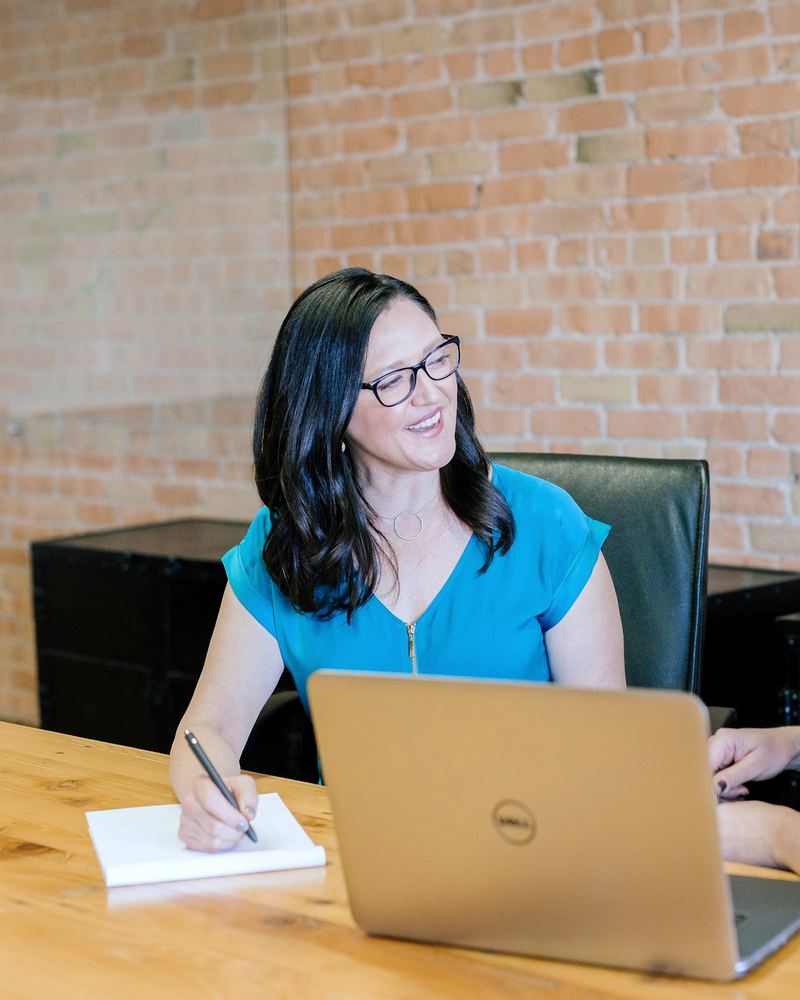 Two professionals in a face-to-face meeting at a conference table with a laptop